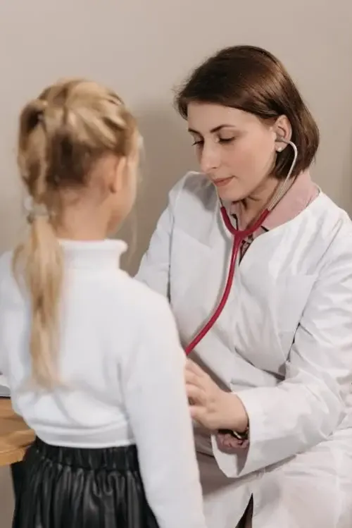 image of a doctor checking a kiddo's heartbeat